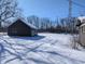 Exterior view of a house with a large backyard covered in snow, bare trees and a utility pole at 401 W Edwards Ave, Indianapolis, IN 46217