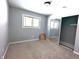 A carpeted bedroom with light-gray painted walls, a large window, and a sliding-door closet with mirrored doors at 401 W Edwards Ave, Indianapolis, IN 46217