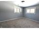 A carpeted bedroom with light-gray painted walls and two side-by-side large windows at 401 W Edwards Ave, Indianapolis, IN 46217
