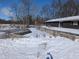 View of the house from the backyard, surrounded by snow-covered ground and trees at 401 W Edwards Ave, Indianapolis, IN 46217