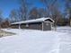 A snow-covered backyard with a house that has a dark exterior and a sliding glass door at 401 W Edwards Ave, Indianapolis, IN 46217