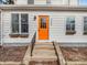 Close-up of the vibrant orange front door of a charming two-story home with window boxes at 422 E Main St, Lebanon, IN 46052