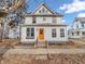 A quaint two-story home with a vibrant orange door offers a welcoming and classic facade at 422 E Main St, Lebanon, IN 46052