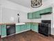 Kitchen boasts black appliances, butcher block counters, white subway tile, chandelier, and green cabinetry at 422 E Main St, Lebanon, IN 46052