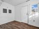 Unfurnished room with hardwood-style floor, window, and a white door with glass at 422 E Main St, Lebanon, IN 46052