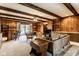 A wood paneled living room with a bar, dining area, ceiling fan, and comfortable seating area at 426 Oakwood Dr, Indianapolis, IN 46260
