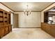 Cozy living room featuring a vintage chandelier, light carpet, and a large wooden cabinet on the right side at 426 Oakwood Dr, Indianapolis, IN 46260