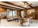 Living room with wood paneling, carpeted floors, wood beams, dining area, and comfortable seating area at 426 Oakwood Dr, Indianapolis, IN 46260