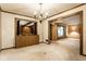 Spacious living room with elegant chandelier and a large opening to an adjacent room with large windows at 426 Oakwood Dr, Indianapolis, IN 46260