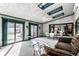 Sunroom featuring bright natural light, brick walls, skylights, a ceiling fan, and sliding doors to the backyard at 426 Oakwood Dr, Indianapolis, IN 46260