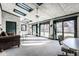 Bright sunroom with white brick walls, skylights, ceiling fan, and sliding glass doors to the backyard at 426 Oakwood Dr, Indianapolis, IN 46260