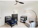 Charming Bedroom with a black crib, dresser, ceiling fan, and a cozy rocking chair at 4425 Maize Ln, Whitestown, IN 46075