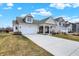 View of the house with a large driveway and well-maintained lawn in a residential neighborhood at 4425 Maize Ln, Whitestown, IN 46075