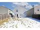Backyard with a two-story home, a fenced yard and grass with patches of snow at 4438 Fullwood Ct, Indianapolis, IN 46254