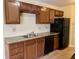 An eat-in kitchen provides ample storage with wood cabinets and black appliances with stone countertops at 4438 Fullwood Ct, Indianapolis, IN 46254