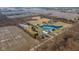 Aerial view of the property with a large pond, multiple buildings, open fields, and surrounding trees at 4981 E County Road 200 S, Avon, IN 46123