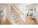 Bright foyer showcasing a staircase with iron spindles and a view into a comfortably furnished sitting room at 4981 E County Road 200 S, Avon, IN 46123