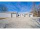 Large three-car garage features an extra-wide gravel parking area and simple architecture at 4981 E County Road 200 S, Avon, IN 46123