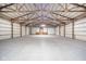 Spacious garage with exposed beam ceiling and smooth concrete flooring, providing plenty of room for vehicles and projects at 4981 E County Road 200 S, Avon, IN 46123