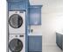 Laundry area features blue cabinets, white counters, and stacked washer and dryer at 4981 E County Road 200 S, Avon, IN 46123