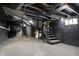 Unfinished basement with exposed utilities provides ample storage or renovation potential at 5053 E Michigan St, Indianapolis, IN 46201