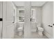Bright bathroom with two separate toilet areas featuring new fixtures and neutral paint at 5053 E Michigan St, Indianapolis, IN 46201