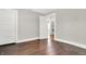 An empty bedroom features hardwood floors, neutral walls, and a white door leading to another room at 5053 E Michigan St, Indianapolis, IN 46201