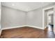 A clean bedroom showcases beautiful hardwood flooring, fresh gray paint, and white trim at 5053 E Michigan St, Indianapolis, IN 46201