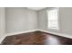 This bright bedroom features a window with natural light, hardwood floors, and neutral paint at 5053 E Michigan St, Indianapolis, IN 46201
