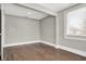An empty, clean room brightened by natural light features hardwood floors and crisp, white trim at 5053 E Michigan St, Indianapolis, IN 46201
