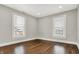 Bright bedroom featuring hardwood floors, multiple windows for natural light, and fresh trim and paint at 5053 E Michigan St, Indianapolis, IN 46201