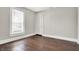 This bright bedroom features a window with natural light, hardwood floors, and neutral paint at 5053 E Michigan St, Indianapolis, IN 46201
