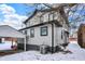Rear exterior view of a gray home with black trim details on a lot covered in snow at 5053 E Michigan St, Indianapolis, IN 46201