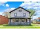 Two-story home featuring a covered porch and a well-maintained lawn at 5053 E Michigan St, Indianapolis, IN 46201
