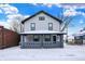 Charming two-story home with a covered front porch and snowy yard at 5053 E Michigan St, Indianapolis, IN 46201