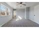 Bright bedroom featuring a ceiling fan, carpet flooring, and a large window at 5124 Wexford Rd, Indianapolis, IN 46226