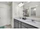 Bright bathroom with dual sinks, gray cabinets, quartz countertop, and tiled shower in the background at 5648 Juniper Ct, Whitestown, IN 46075