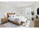Bright bedroom with a wooden bed frame, bench, neutral decor, and natural light from a window at 5648 Juniper Ct, Whitestown, IN 46075