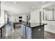 Open-concept design combines a modern kitchen with gray cabinets, a central island, and a view of the living area at 5648 Juniper Ct, Whitestown, IN 46075