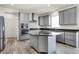 Modern kitchen features gray cabinets, stainless steel appliances, and a center island with countertop seating at 5648 Juniper Ct, Whitestown, IN 46075