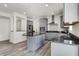 Modern kitchen with stainless steel appliances, gray cabinets, a center island, and an open view to the dining area at 5648 Juniper Ct, Whitestown, IN 46075