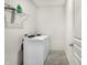 Bright laundry room with modern washer and dryer, along with a shelf and tiled floor at 5648 Juniper Ct, Whitestown, IN 46075