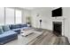 Comfortable living room with a plush blue sofa, fireplace, modern floors, and abundant natural light at 5648 Juniper Ct, Whitestown, IN 46075