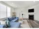 Inviting living room featuring a cozy fireplace, blue sofa, modern flooring, and lots of natural light at 5648 Juniper Ct, Whitestown, IN 46075