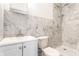 Modern bathroom featuring marble tile, new fixtures, vanity, toilet, and walk-in shower at 5757 E 21St St, Indianapolis, IN 46218