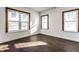 Bedroom with two windows, dark vinyl floors, white trim and fresh neutral paint at 5757 E 21St St, Indianapolis, IN 46218