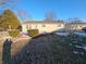Back of the ranch-style home with snowy patches and trees at 5816 Coppock Ln, Indianapolis, IN 46221