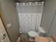This bathroom features a toilet, shower with curtain, and tiled floors at 5816 Coppock Ln, Indianapolis, IN 46221
