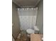This bathroom features a toilet, shower with curtain, and tiled floors at 5816 Coppock Ln, Indianapolis, IN 46221