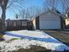 Charming one-story home with attached garage and a brick and vinyl facade, with snow covered lawn at 5816 Coppock Ln, Indianapolis, IN 46221